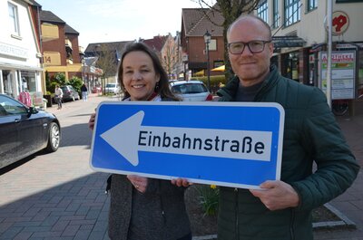 Sophie Schad und Thomas Kuberski halten ein EInbahnstraßenschild in den Händen
