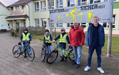 Schüler mit Fahrrädern und Warnwesten vor der Grundschule Neuenwalde