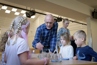 Werner Köhler schaut Kindern beim Forschen über die Schulter