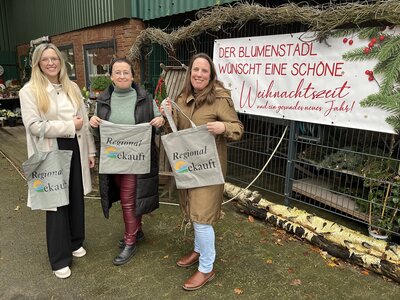 Wirtschaftsförderin Katja Beier und Klimaschutzmanagerin Katharina Koop mit Bärbel Pape vor ihrem Blumengeschäft in Kührstedt